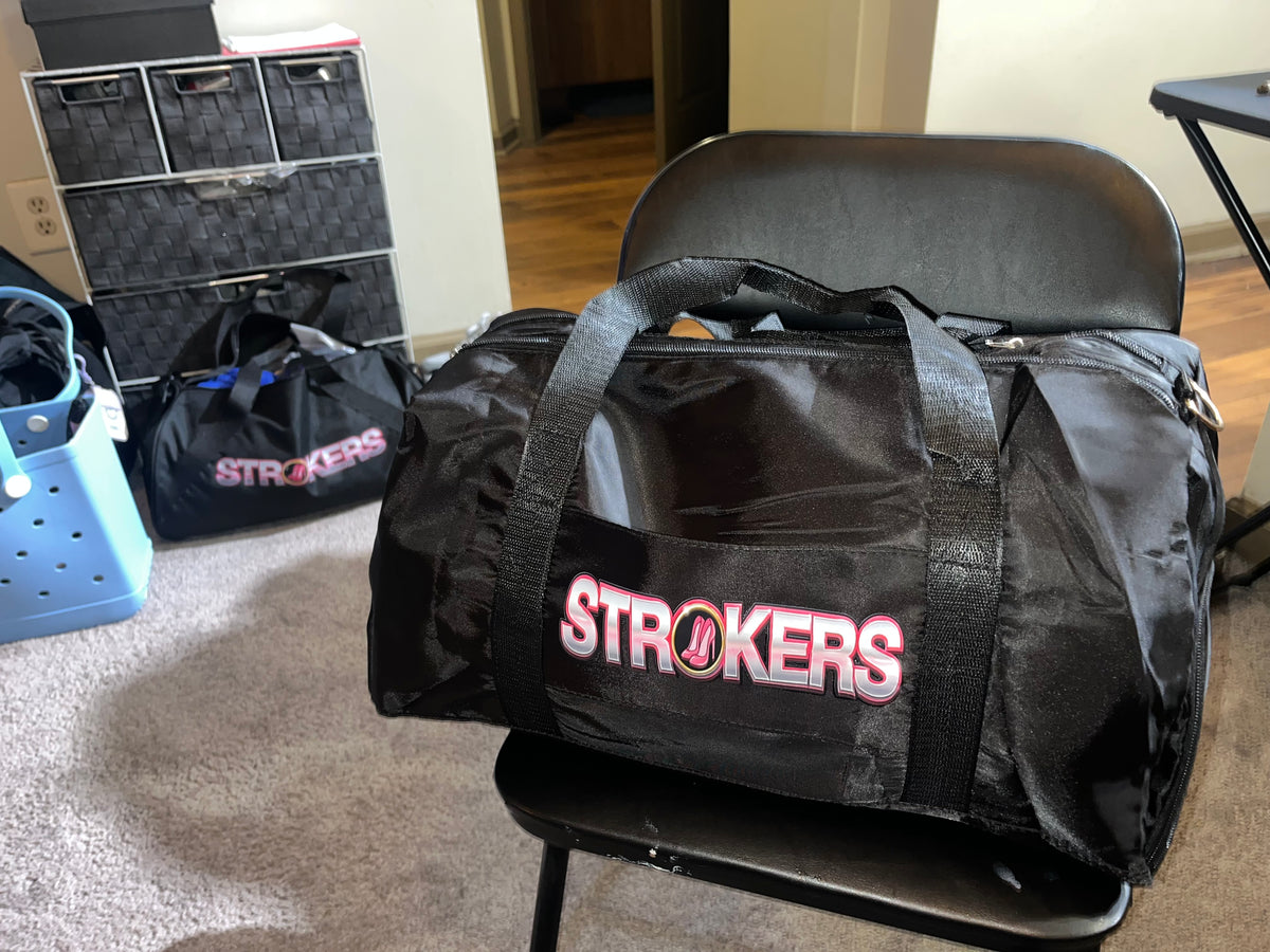 Black duffel bag with pink and white Strokers logo and two carry handles